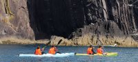Sea kayaking under cliffs