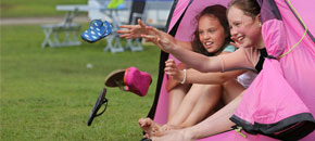 Two girls sitting in a pink tent