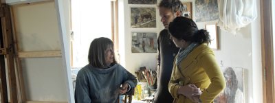 Couple talk to artist in studio