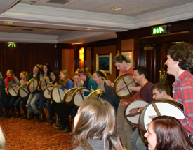 Enjoy a unique traditional Irish experience playing Ireland’s ancient drum. People playing bodhráns at Comhaltas Ceoltóirí Éireann