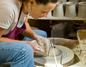 Crafts people and artists can be found working at Castlecomer Estate. Woman sculpting a cup on a pottery wheel