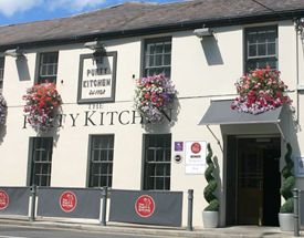 Famous locally for its fresh seafood - visit one of Dublin's oldest pubs. Sunny front exterior of the Purty Kitchen with flower baskets