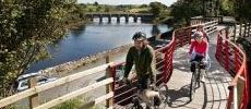 230x100_two_cyclists_crossing_wooden_bridge